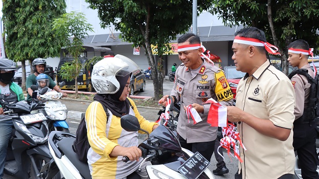 Merah Putihkan Kota Bontang, Kapolres Bontang Bagikan Bendera dan Merchandise kepada Masyarakat di Simpang 3 Ramayana