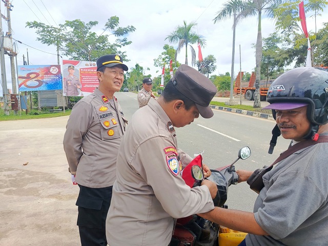 Ajak Meriahkan HUT RI ke-79, Kapolsek Bontang Barat bagikan Bendera Merah Putih kepada Masyarakat